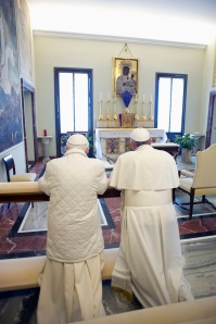 Pope Francis prays with retired Pope Benedict XVI after arriving at the papal summer residence in Castel Gandolfo, Italy, March 23. Pope Francis travelled by helicopter from the Vatican to Castel Gandolfo for the private meeting with the former pontiff. (CNS photo/L'Osservatore Romano via Reuters) 