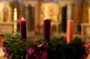 Lit candle seen on Advent wreath during Mass in Crypt Church at national shrine in Washington